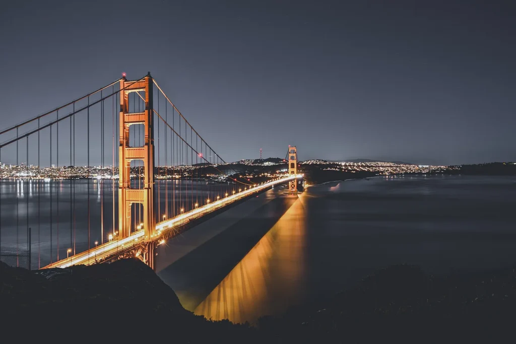 Golden Gate Bridge illuminated above San Francisco Bay at dusk.