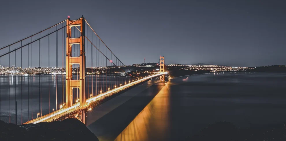 Golden Gate Bridge illuminated above San Francisco Bay at dusk.