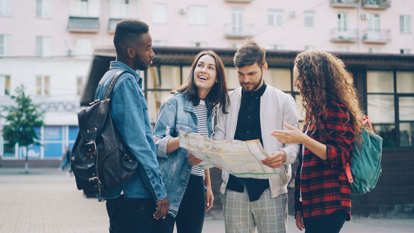 Four young adults looking at a map on a city street.